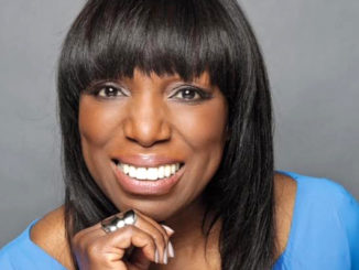 Smiling woman with straight black hair and bangs.